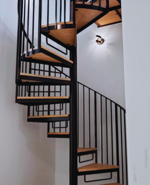 Luxury home design detail – black steel spiral staircase maximizing space and adding architectural drama 